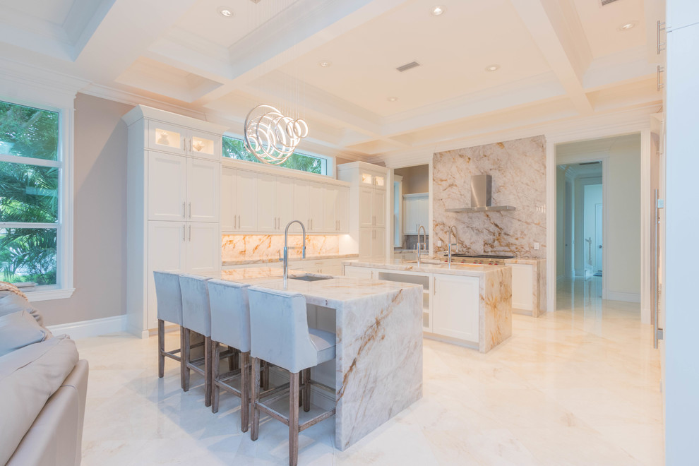 Photo of an expansive transitional u-shaped open plan kitchen in Other with an undermount sink, flat-panel cabinets, white cabinets, quartzite benchtops, white splashback, stone slab splashback, marble floors, multiple islands and white floor.