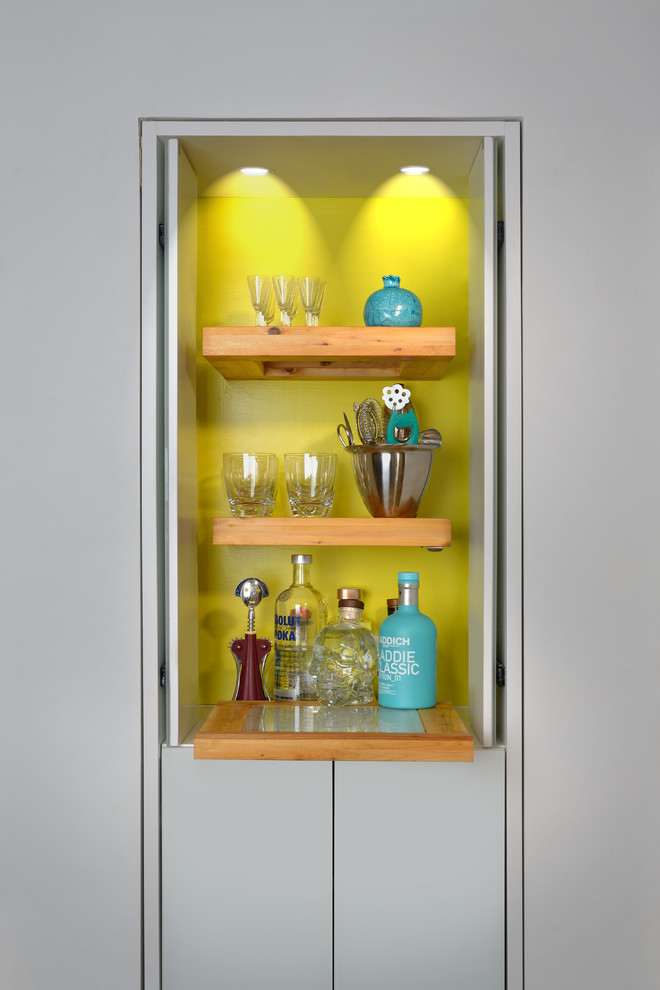 Design ideas for a modern home bar in Toronto with flat-panel cabinets, wood benchtops and yellow splashback.