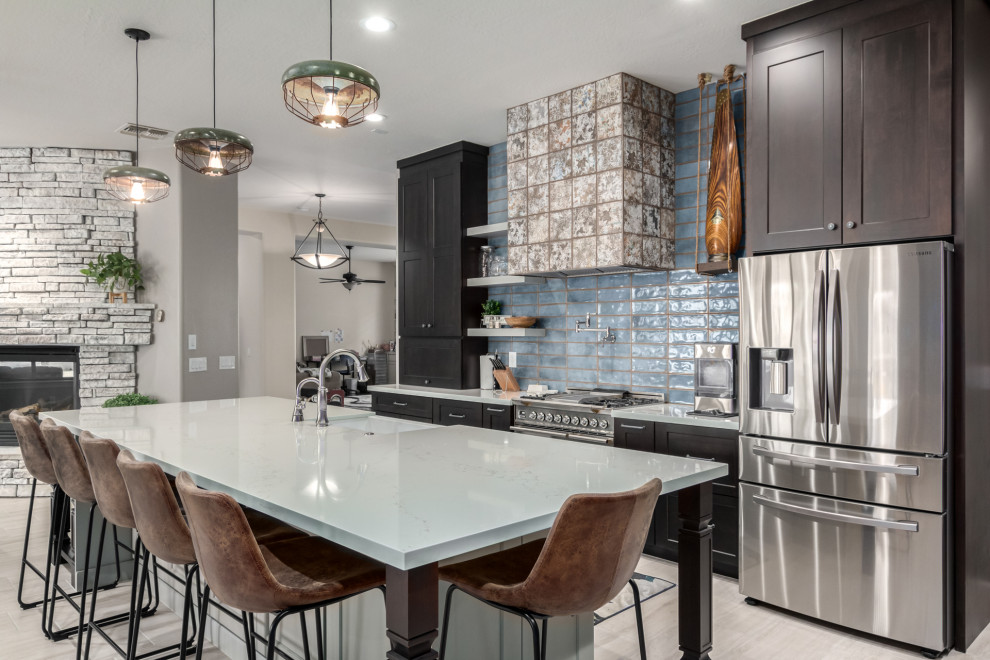 This is an example of an expansive country l-shaped eat-in kitchen in Phoenix with a farmhouse sink, shaker cabinets, dark wood cabinets, quartz benchtops, blue splashback, subway tile splashback, with island and white benchtop.