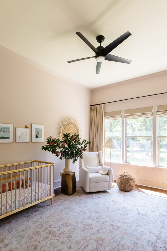 Aménagement d'une chambre de bébé fille classique de taille moyenne avec un mur rose, parquet foncé et un sol marron.