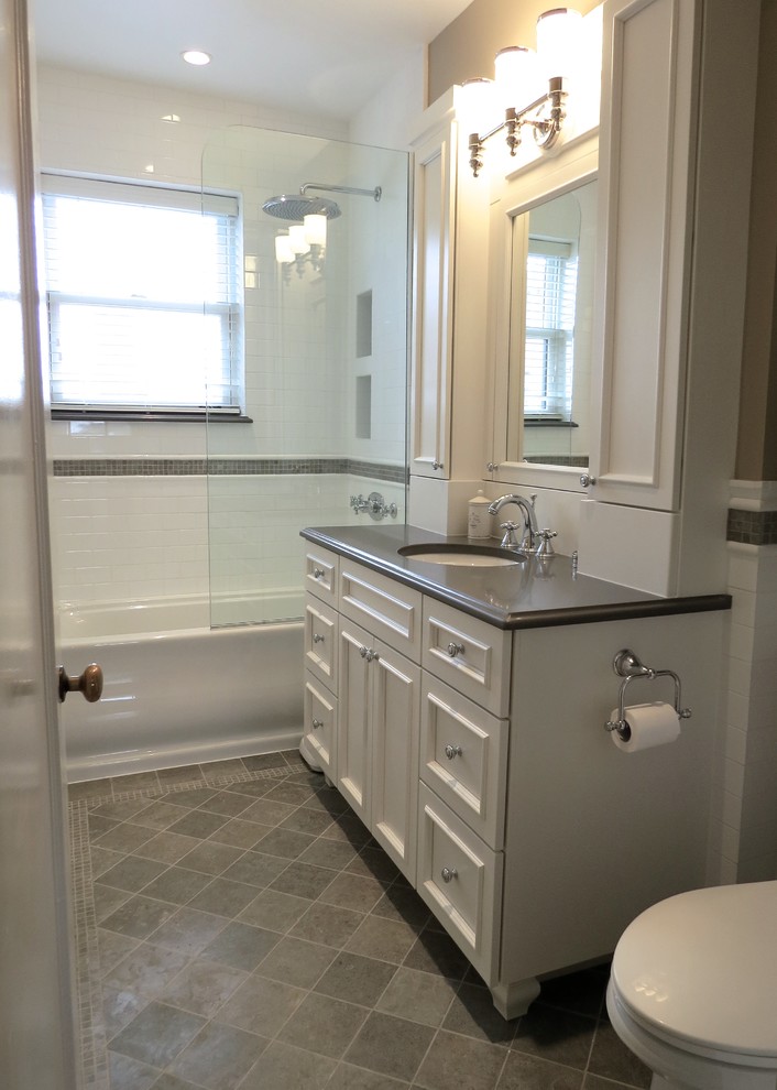 This is an example of a traditional master bathroom in Chicago with a wall-mount sink, recessed-panel cabinets, white cabinets, engineered quartz benchtops, an alcove tub, white tile, ceramic tile and limestone floors.