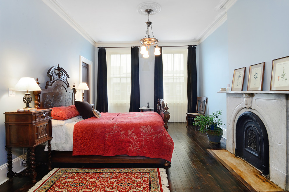 Traditional bedroom in New York with blue walls and dark hardwood floors.