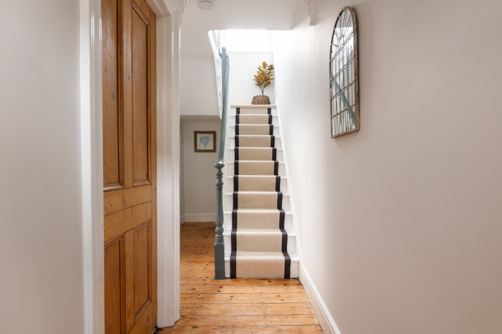 This is an example of a large traditional entry hall in Cornwall with white walls, medium hardwood floors, a single front door, a blue front door and brown floor.