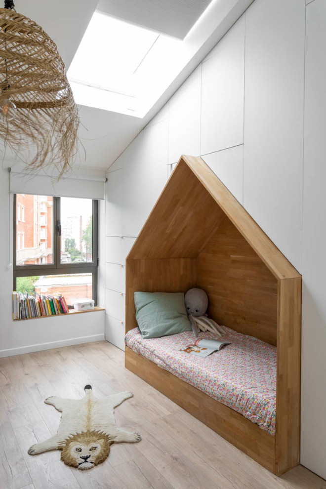 Ispirazione per una cameretta per bambini da 4 a 10 anni di medie dimensioni con pareti bianche, parquet chiaro e pavimento beige