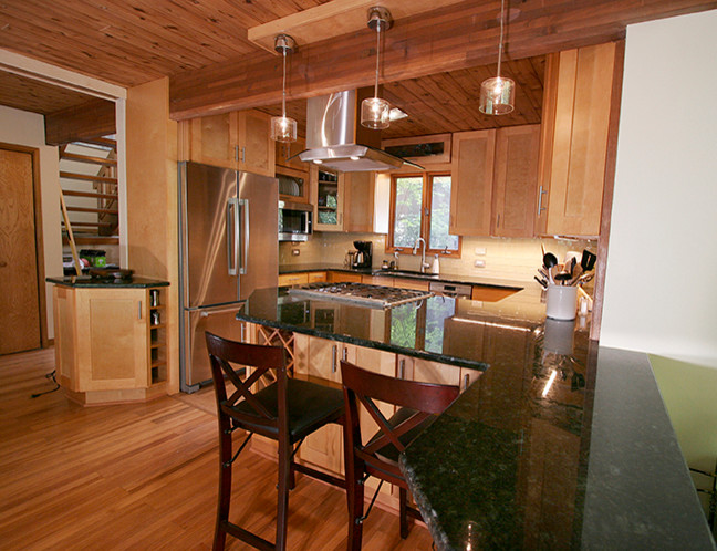 Small transitional l-shaped porcelain tile eat-in kitchen photo with shaker cabinets, light wood cabinets, granite countertops, beige backsplash, glass tile backsplash, stainless steel appliances and a peninsula