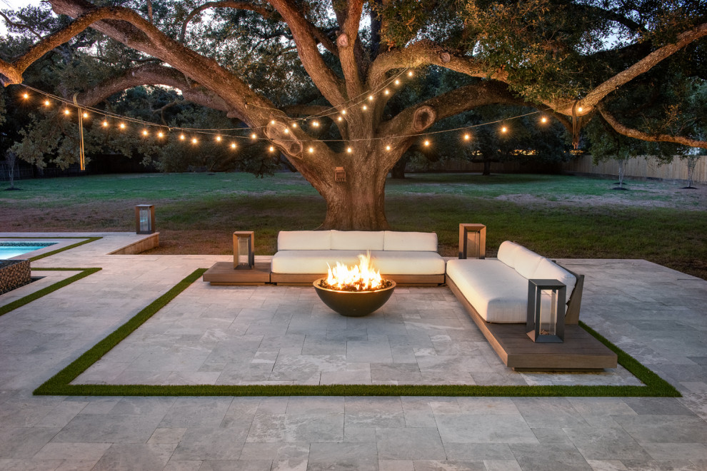 Diseño de piscina romántica grande rectangular en patio trasero con adoquines de piedra natural