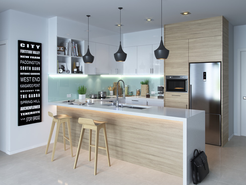 Design ideas for a small contemporary u-shaped open plan kitchen in Brisbane with an undermount sink, flat-panel cabinets, light wood cabinets, glass sheet splashback, stainless steel appliances, a peninsula, beige floor, marble benchtops, green splashback, cement tiles and white benchtop.