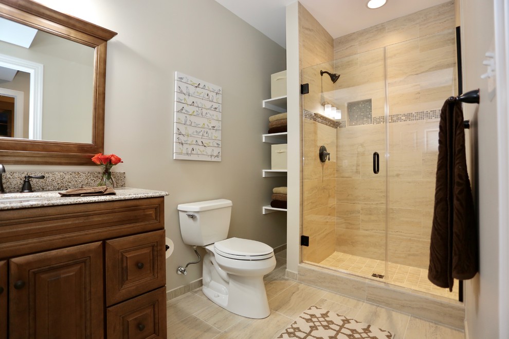 This is an example of a mid-sized transitional 3/4 bathroom in DC Metro with raised-panel cabinets, dark wood cabinets, an alcove shower, a two-piece toilet, beige tile, slate, grey walls, porcelain floors, an undermount sink, granite benchtops, beige floor and a hinged shower door.
