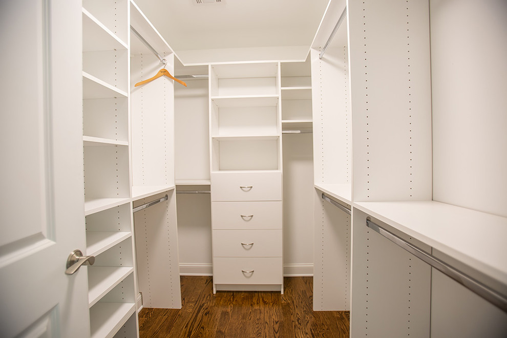 Photo of a mid-sized transitional gender-neutral walk-in wardrobe in Philadelphia with white cabinets, medium hardwood floors and flat-panel cabinets.