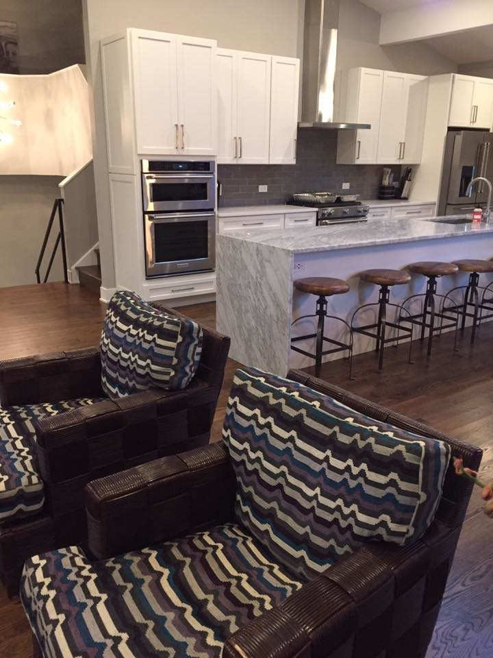 Example of a large transitional u-shaped medium tone wood floor and brown floor open concept kitchen design in Chicago with an undermount sink, shaker cabinets, white cabinets, quartzite countertops, gray backsplash, subway tile backsplash, stainless steel appliances and an island
