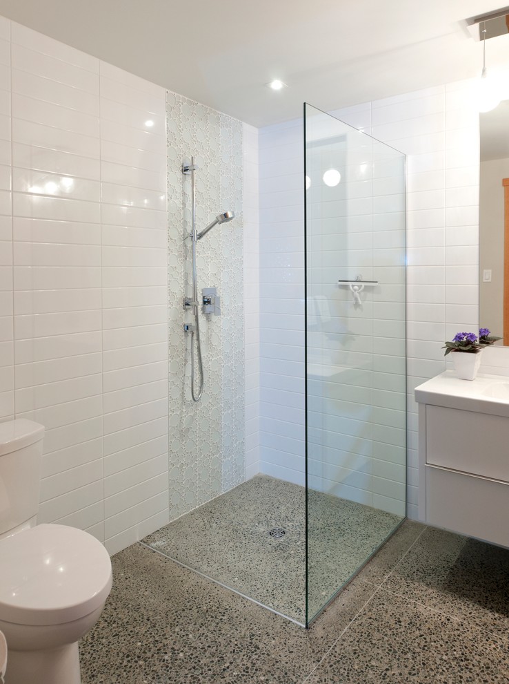Photo of a large contemporary 3/4 bathroom in Vancouver with flat-panel cabinets, white cabinets, solid surface benchtops, white tile, subway tile, an open shower, a one-piece toilet, an integrated sink, white walls and concrete floors.