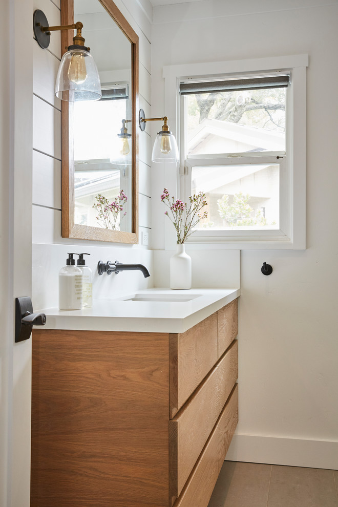 Photo of a country bathroom in San Francisco with brown cabinets, a corner shower, white tile, ceramic tile, white walls, porcelain floors, an undermount sink, engineered quartz benchtops, a hinged shower door and white benchtops.