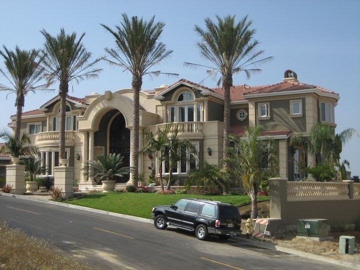 This is an example of a large mediterranean one-storey stucco brown house exterior in San Francisco with a hip roof and a tile roof.