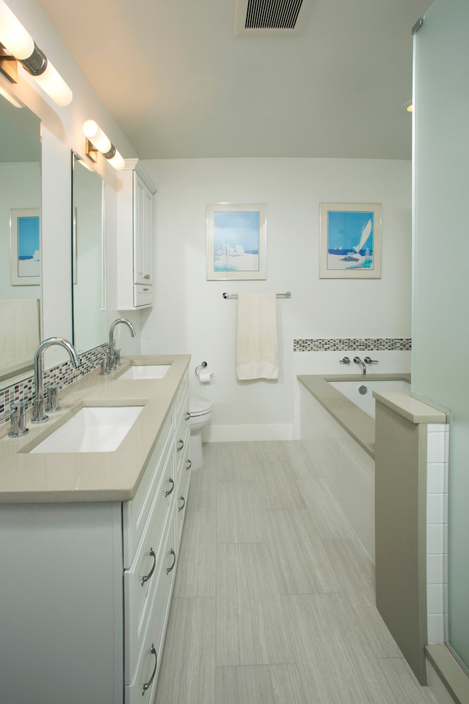 Inspiration for a mid-sized transitional master brown tile and mosaic tile porcelain tile corner bathtub remodel in DC Metro with an undermount sink, recessed-panel cabinets, white cabinets, quartz countertops, a two-piece toilet and white walls
