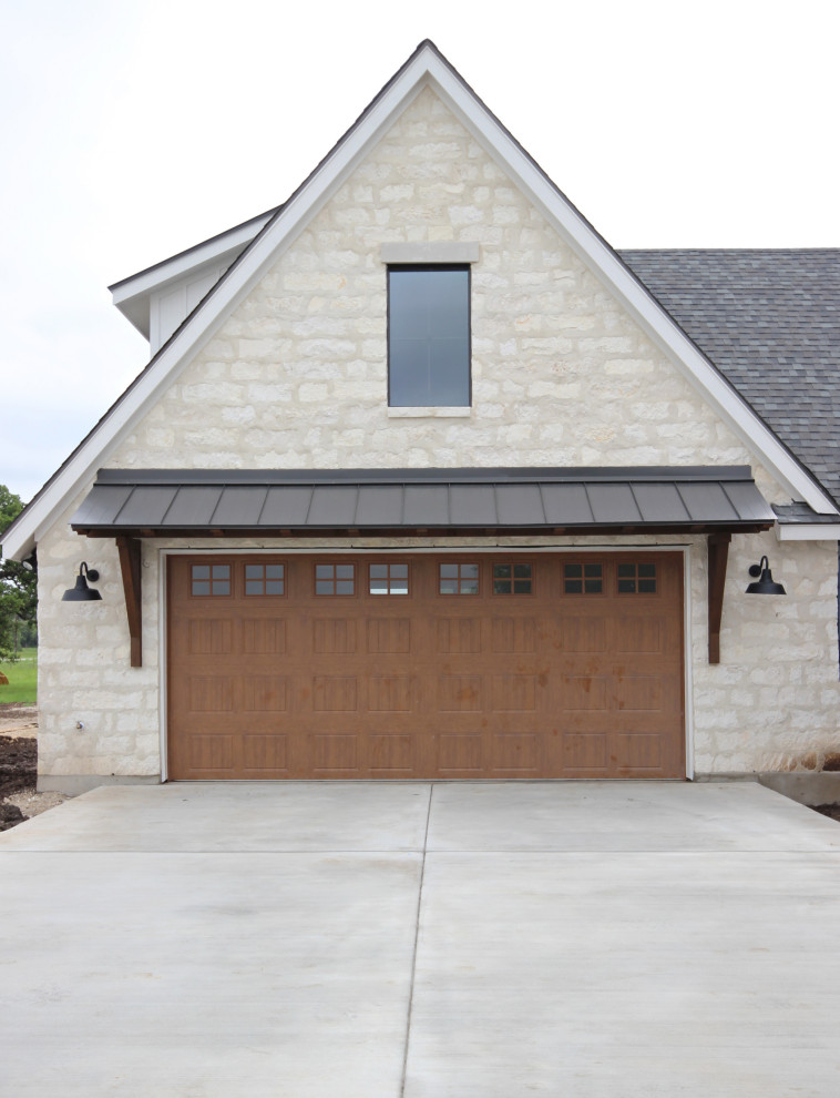 Example of a country attached two-car garage design in Austin