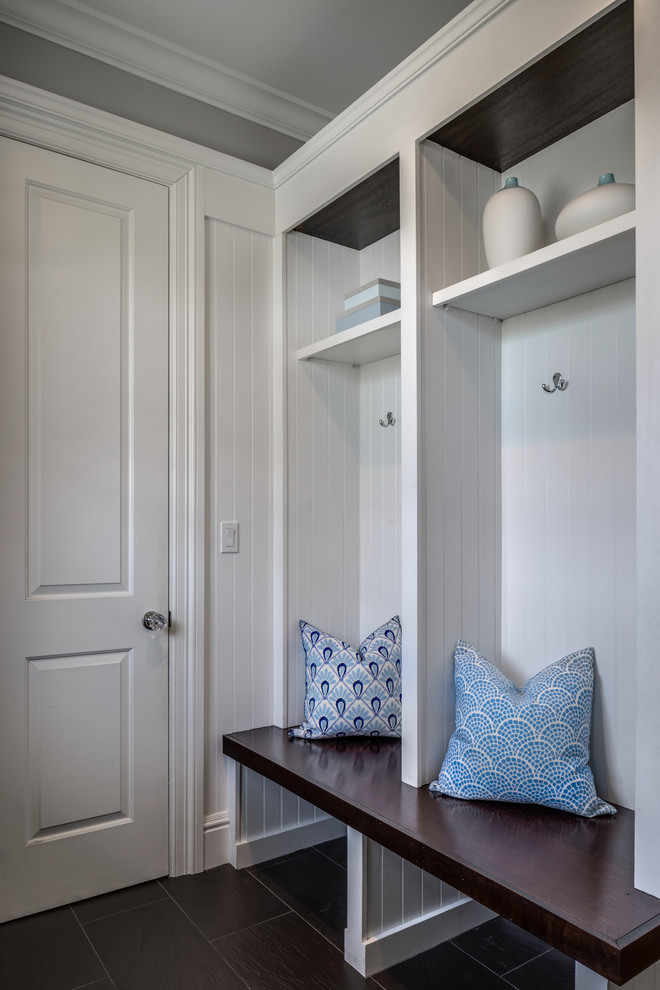 Inspiration for a mid-sized beach style mudroom in New York with white walls, dark hardwood floors, a single front door, a white front door and brown floor.