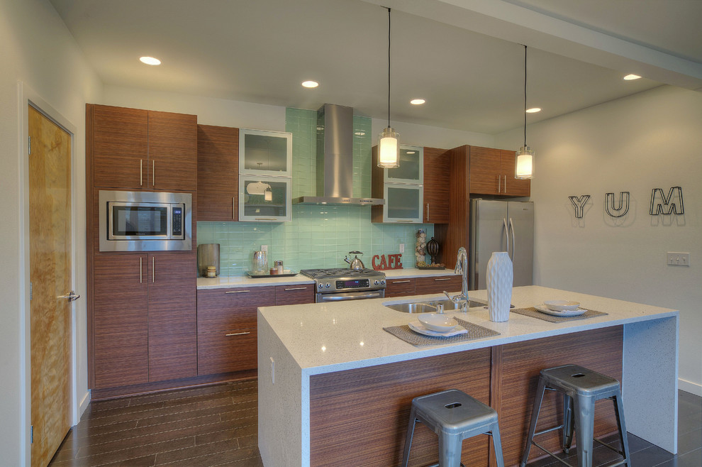 Inspiration for a mid-sized modern dark wood floor eat-in kitchen remodel in Seattle with an undermount sink, flat-panel cabinets, medium tone wood cabinets, quartzite countertops, green backsplash, glass tile backsplash, stainless steel appliances and an island