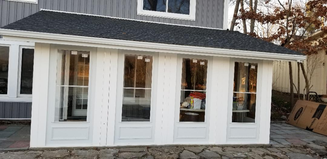 Concealed screen storm doors enclose sun porch and add year-round living space