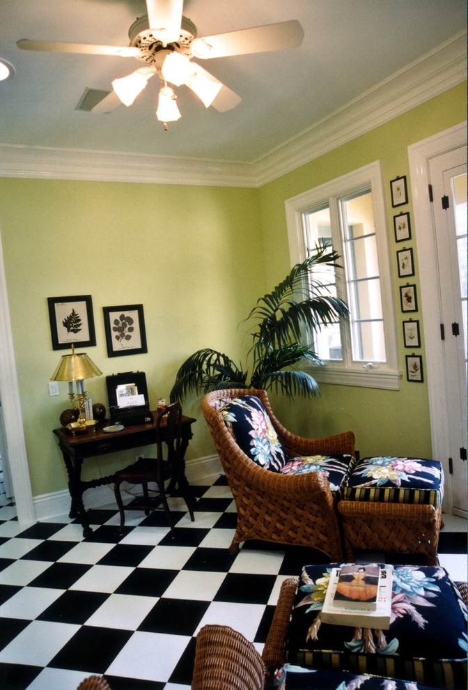This is an example of a mid-sized traditional home office in Los Angeles with yellow walls, ceramic floors, a freestanding desk and black floor.
