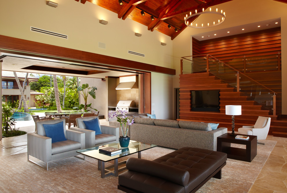 Photo of a large tropical open concept living room in Hawaii with slate floors, a standard fireplace and a wood fireplace surround.