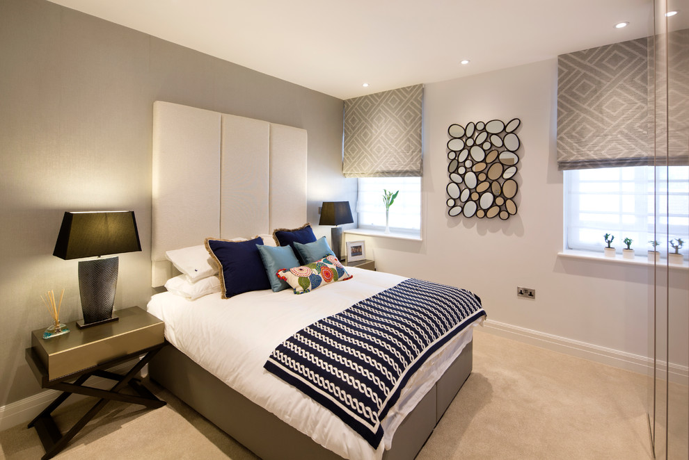 This is an example of a contemporary master bedroom in London with grey walls and carpet.