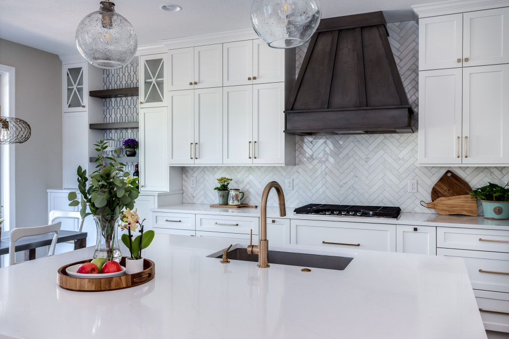 Inspiration for a large transitional galley medium tone wood floor and brown floor open concept kitchen remodel in Denver with an undermount sink, shaker cabinets, white cabinets, quartz countertops, beige backsplash, marble backsplash, stainless steel appliances, an island and white countertops