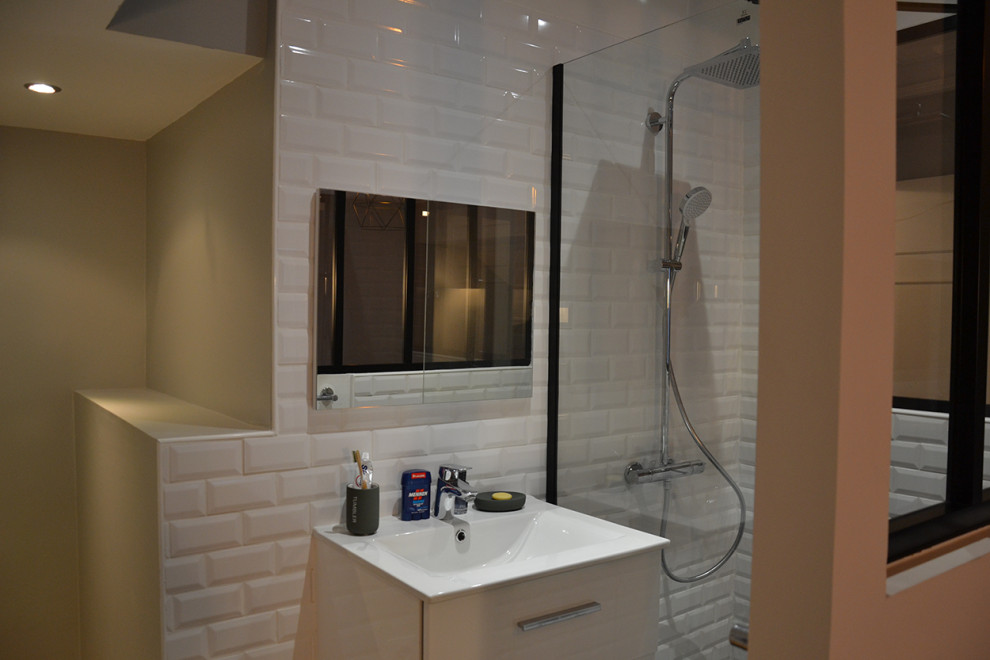 Foto på ett litet funkis badrum med dusch, med vit kakel, keramikplattor, vita väggar, klinkergolv i keramik, ett konsol handfat och svart golv