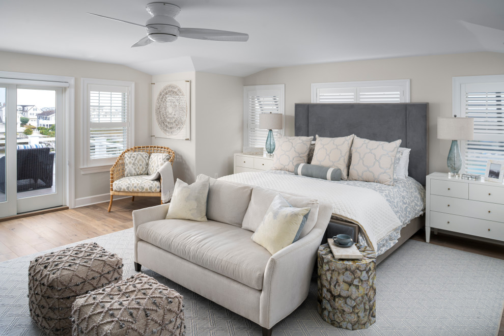 Beach style bedroom in Philadelphia with beige walls, medium hardwood floors and brown floor.