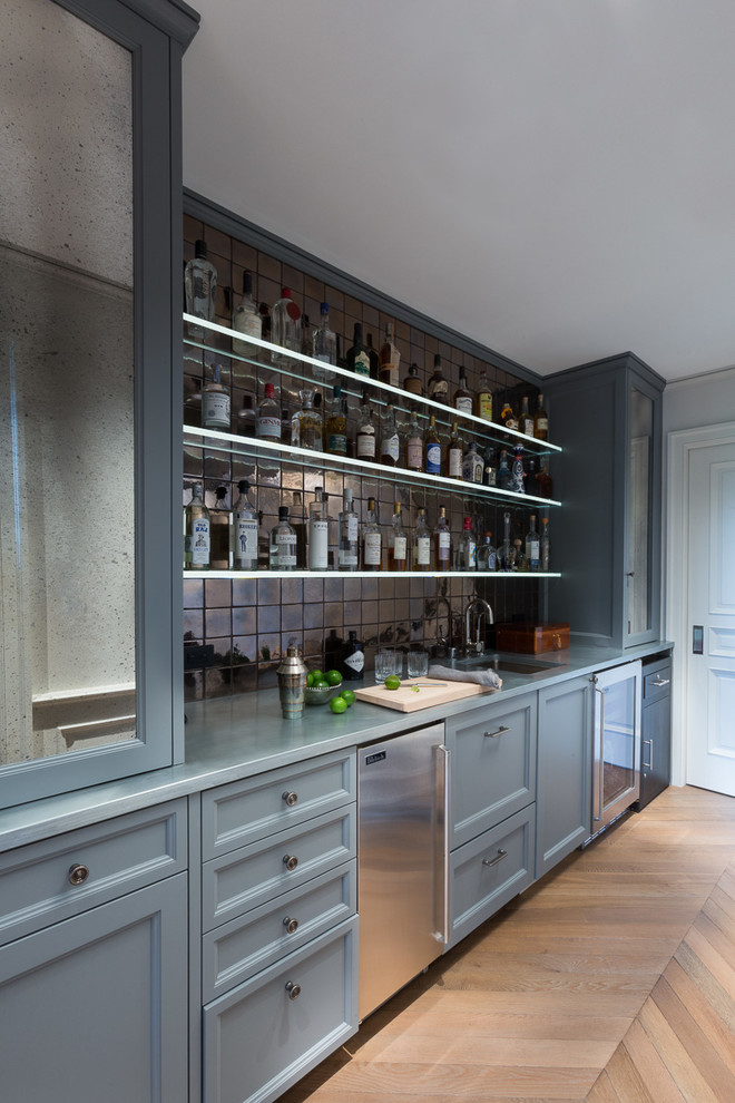 Photo of a transitional single-wall wet bar in San Francisco with an undermount sink, recessed-panel cabinets, blue cabinets, medium hardwood floors and beige floor.