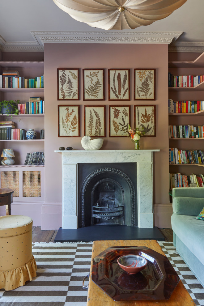 This is an example of a large traditional formal enclosed living room in London with pink walls, dark hardwood flooring, a standard fireplace, a stone fireplace surround, no tv, brown floors and a chimney breast.