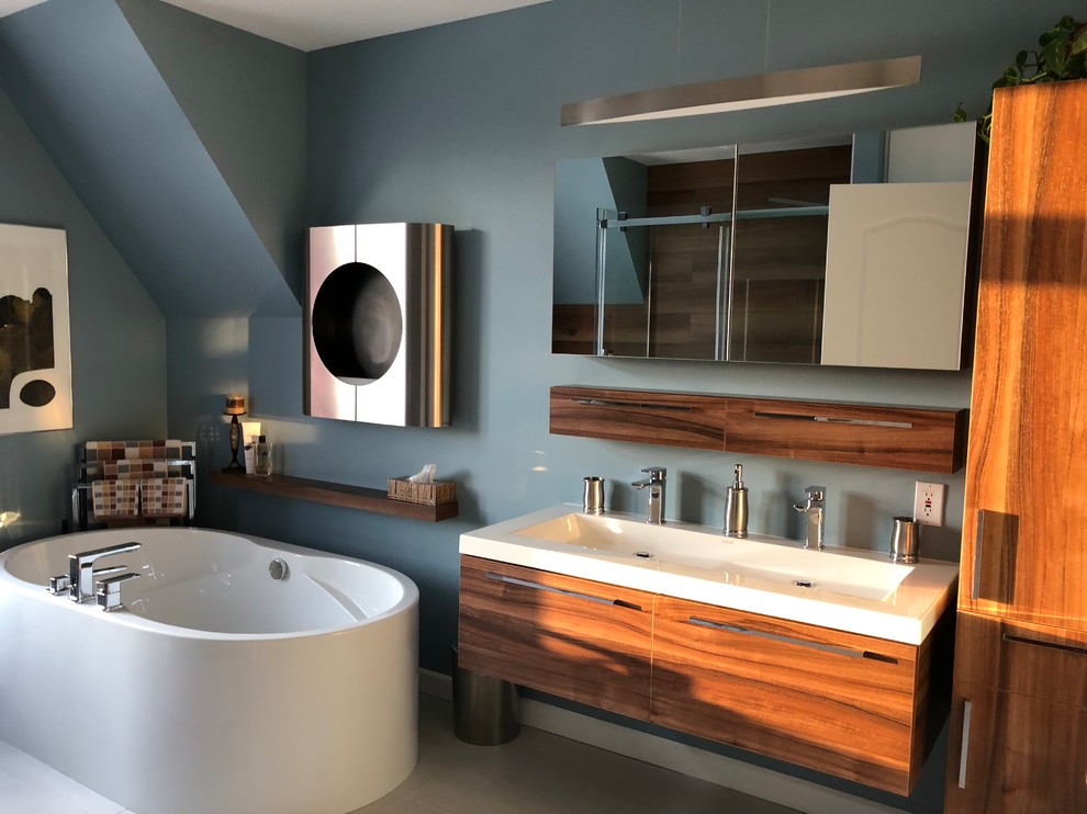 Inspiration for a modern master wet room bathroom in Montreal with medium wood cabinets, a freestanding tub, a one-piece toilet, brown tile, porcelain tile, blue walls, porcelain floors, an integrated sink, white floor, a sliding shower screen and white benchtops.