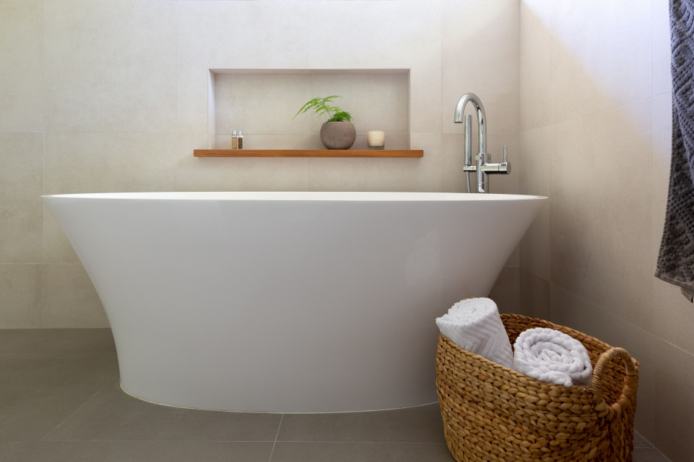 Freestanding bathtub - large transitional master gray tile and ceramic tile ceramic tile and gray floor freestanding bathtub idea with furniture-like cabinets, brown cabinets, a two-piece toilet, white walls, a drop-in sink, quartz countertops and gray countertops