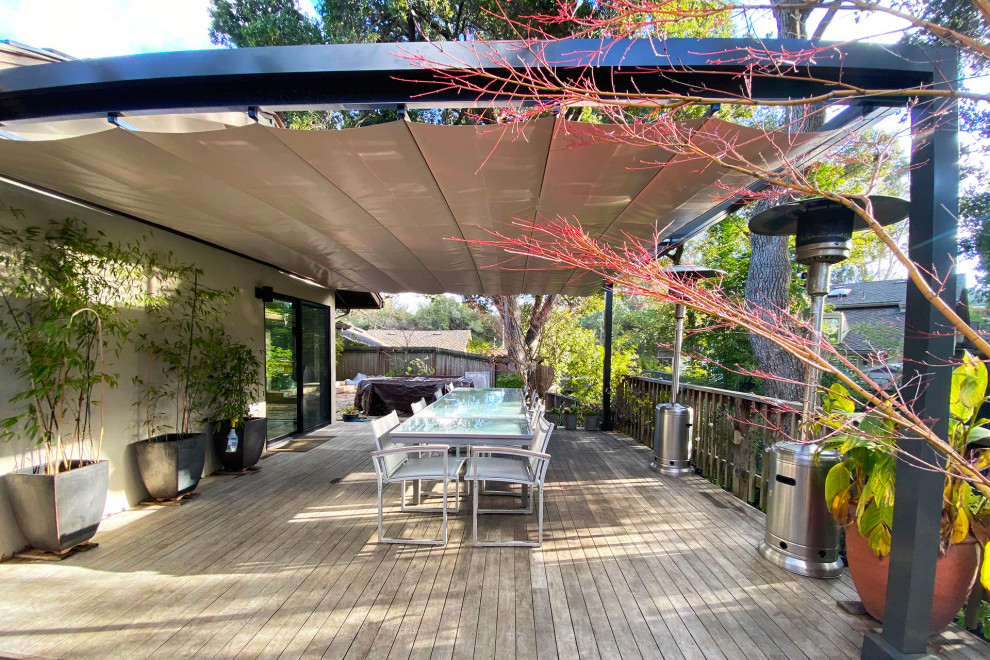 Mid-sized modern backyard and ground level deck in San Francisco with a pergola and wood railing.