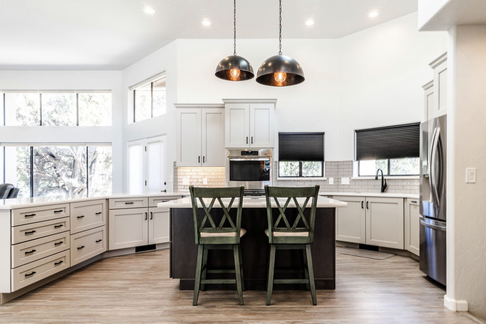 This is an example of a large transitional u-shaped eat-in kitchen in Other with an undermount sink, shaker cabinets, grey cabinets, quartzite benchtops, green splashback, subway tile splashback, stainless steel appliances, vinyl floors, with island, grey floor and white benchtop.