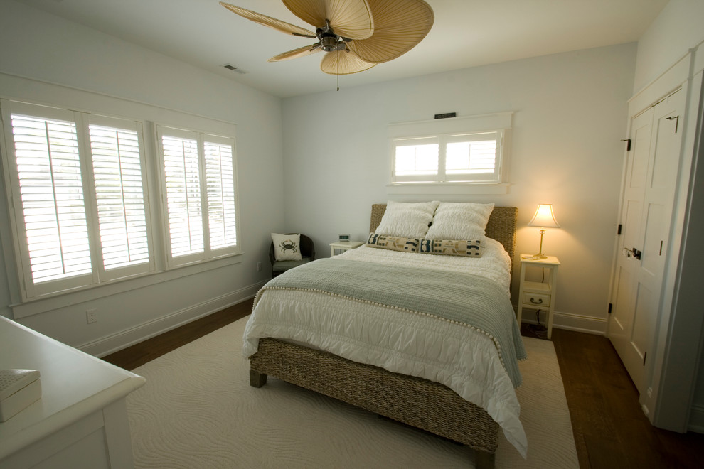 Photo of a mid-sized beach style master bedroom in New York with blue walls and medium hardwood floors.