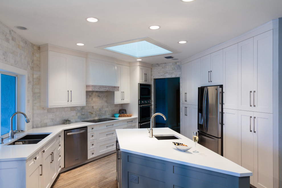 Kitchen - mid-sized transitional l-shaped light wood floor and beige floor kitchen idea in Miami with a double-bowl sink, shaker cabinets, quartz countertops, multicolored backsplash, subway tile backsplash, stainless steel appliances, an island and white countertops