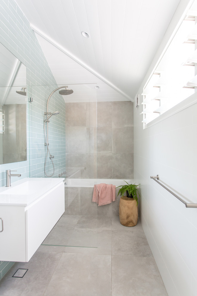 Photo of a small contemporary kids wet room bathroom in Sydney with white cabinets, a drop-in tub, blue tile, subway tile, an integrated sink, grey floor and an open shower.