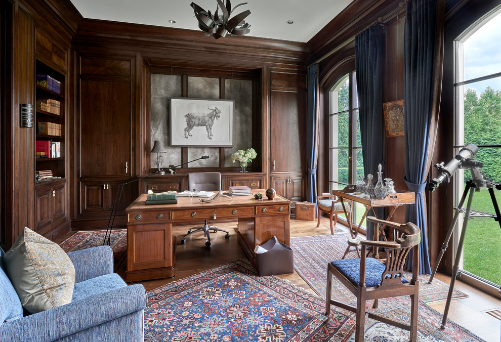 Expansive traditional study room in Chicago with brown walls, light hardwood floors, no fireplace and a freestanding desk.