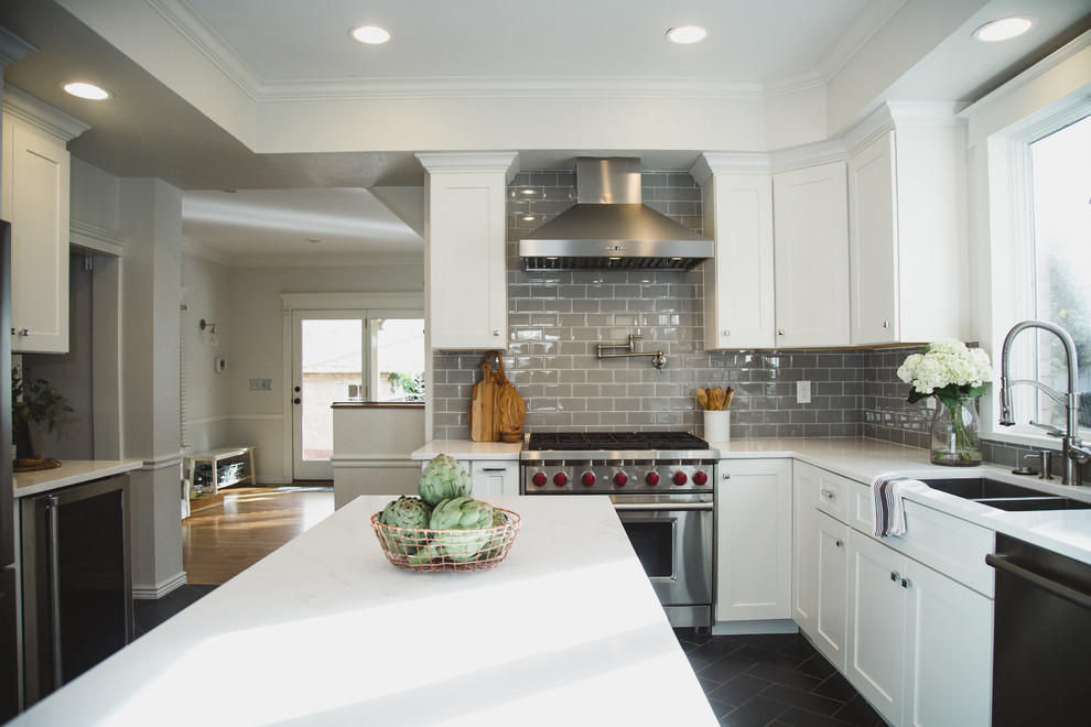 Inspiration for a mid-sized transitional u-shaped porcelain tile enclosed kitchen remodel in Denver with an undermount sink, shaker cabinets, white cabinets, quartz countertops, beige backsplash, subway tile backsplash, stainless steel appliances and an island