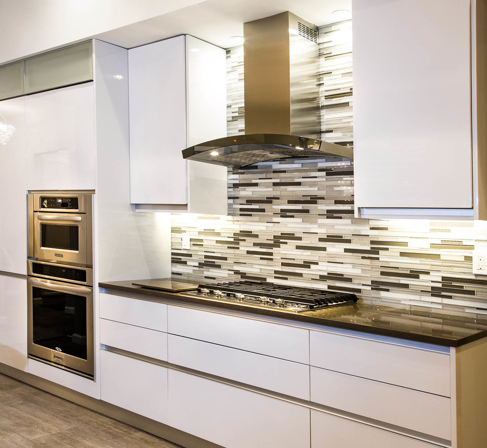 Inspiration for a mid-sized contemporary l-shaped kitchen in New York with an undermount sink, quartz benchtops, glass tile splashback, stainless steel appliances and ceramic floors.
