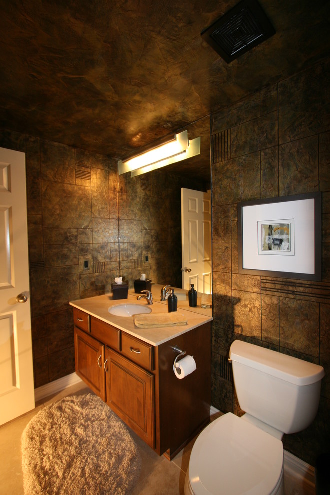 Photo of a mid-sized contemporary powder room with raised-panel cabinets, medium wood cabinets, a two-piece toilet, grey walls, ceramic floors, an undermount sink, solid surface benchtops and beige floor.