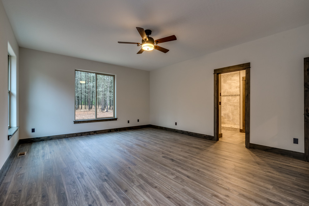 Inspiration for a large rustic laminate floor and brown floor bedroom remodel
