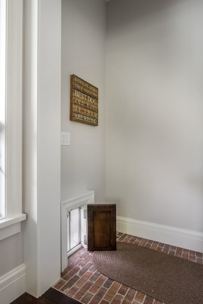 Small country entryway in Salt Lake City with white walls, brick floors and red floor.
