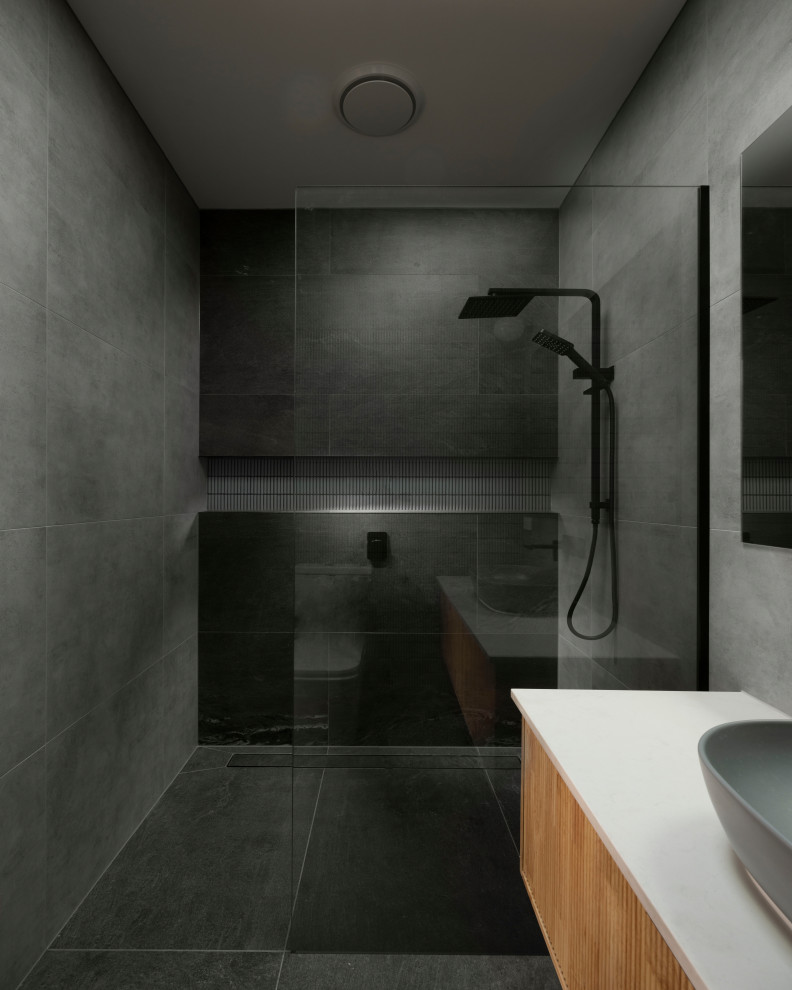 Inspiration for a small contemporary ensuite bathroom in Melbourne with beaded cabinets, brown cabinets, a walk-in shower, a wall mounted toilet, grey tiles, ceramic tiles, grey walls, ceramic flooring, a vessel sink, engineered stone worktops, black floors, an open shower, white worktops, a wall niche, a single sink and a floating vanity unit.