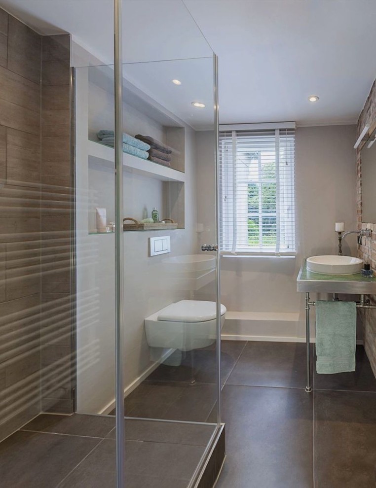 Kleines Industrial Duschbad mit Wandtoilette, Aufsatzwaschbecken, grauen Fliesen, Keramikfliesen, Keramikboden und grauem Boden in Düsseldorf