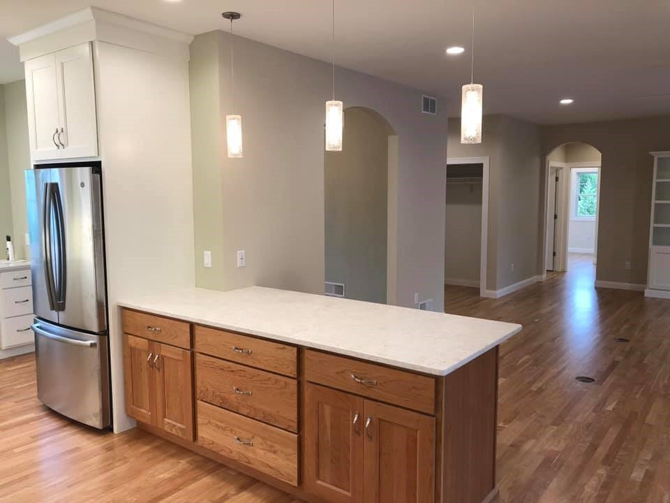 Kitchen - large transitional l-shaped medium tone wood floor kitchen idea with an undermount sink, shaker cabinets, medium tone wood cabinets, quartz countertops, stainless steel appliances, a peninsula and white countertops