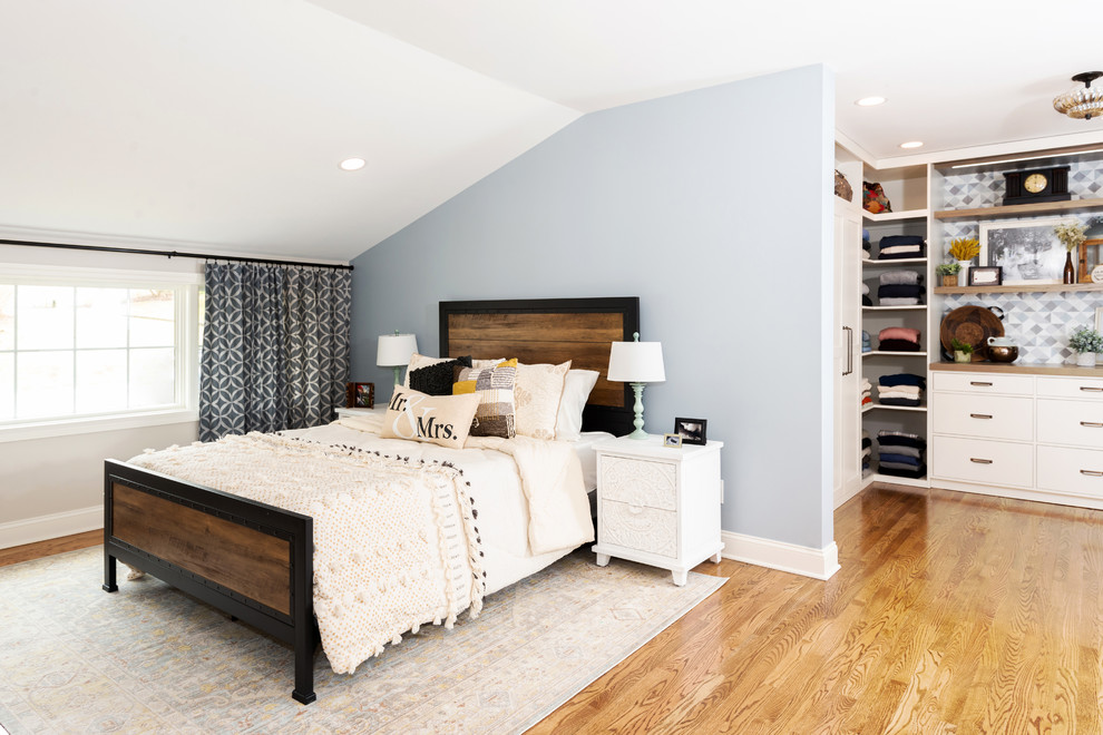This is an example of a transitional bedroom in Other with blue walls, medium hardwood floors and brown floor.