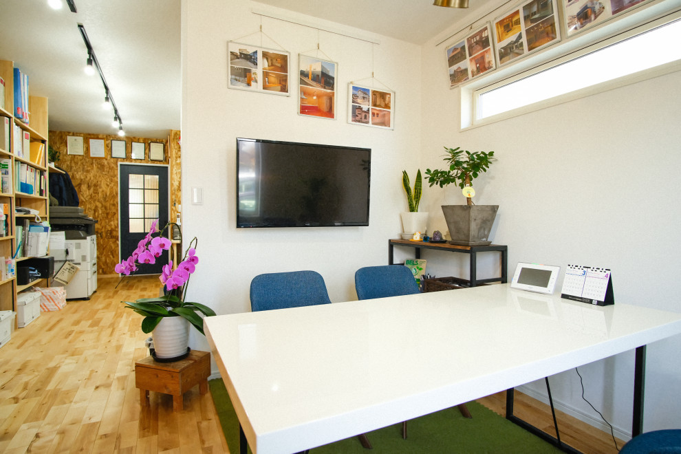 Foto på ett mellanstort funkis hobbyrum, med bruna väggar, ljust trägolv, ett inbyggt skrivbord och beiget golv