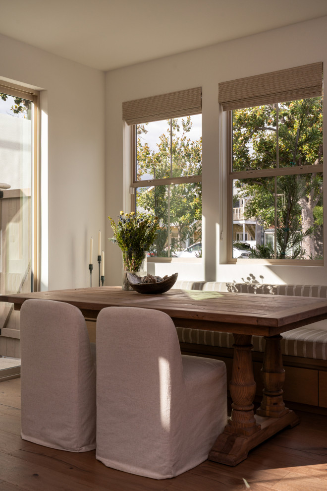 Example of a tuscan medium tone wood floor and brown floor kitchen/dining room combo design in Los Angeles with white walls
