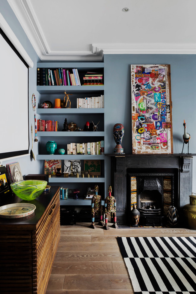 Design ideas for an eclectic living room in London with blue walls, light hardwood floors, a standard fireplace and a plaster fireplace surround.